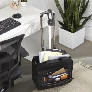 Black rolling laptop bag with telescoping handle beside a desk