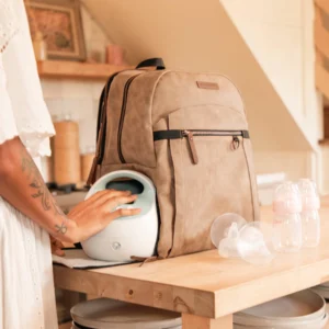 Tan canvas backpack with leather trim on a wooden table